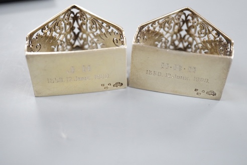 A late Victorian cased pair of pierced silver triangular napkin rings, by Goldsmiths & Silversmiths Co Ltd, London, 1900, with engraved inscription.